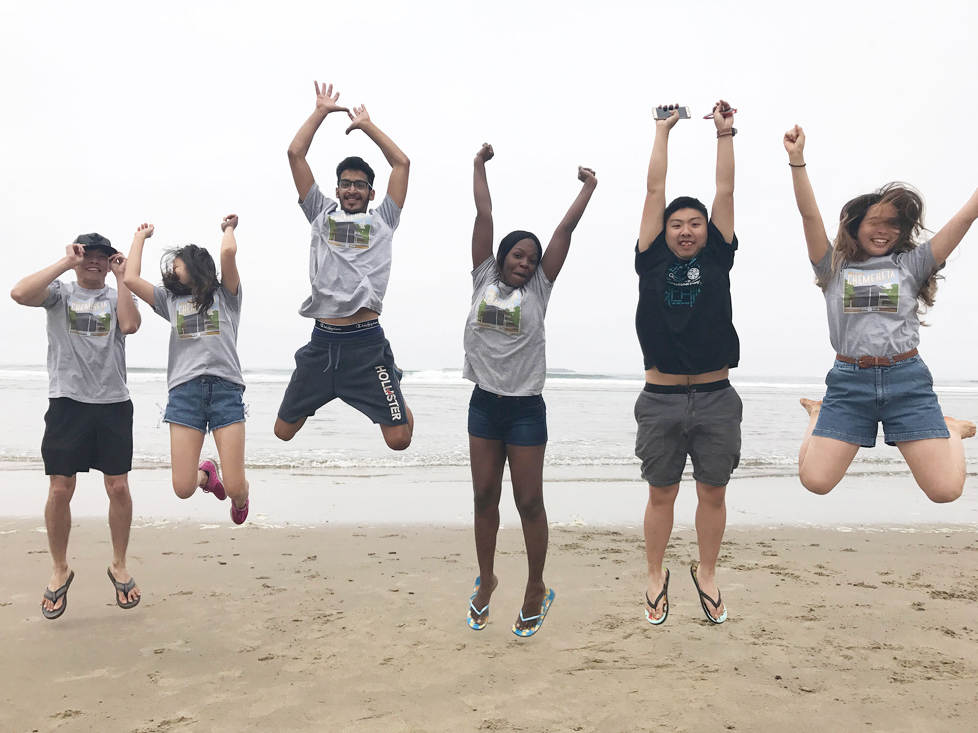 Students jumping in the air at the beach